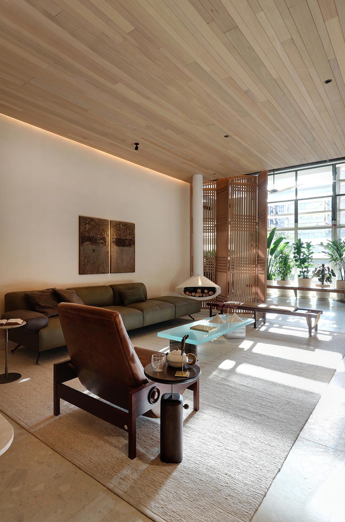 Barbara Dundes Arquitetura - Casa Morada. Projeto da CASACOR São Paulo 2023. Na foto, sala de estar com sofá verde, lareira e divisória vazada.